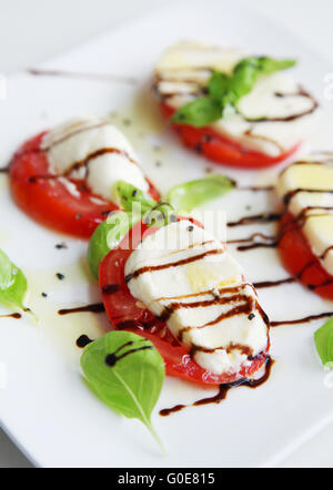 Plate of healthy classic caprese salad with ripe tomatoes and ...