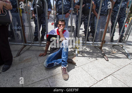 Beirut,Lebanon. 1st May 2016 . A man sits in front of a police barrier as members of the Lebanese communist party and trade unionists staged a rally in central Beirut to celebrate May Day and in support of  national and international workers rights Credit:  amer ghazzal/Alamy Live News Stock Photo