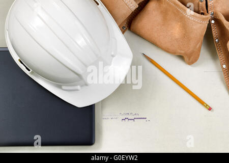 Construction contractor tools resting on top of blue print CAD drawings Stock Photo