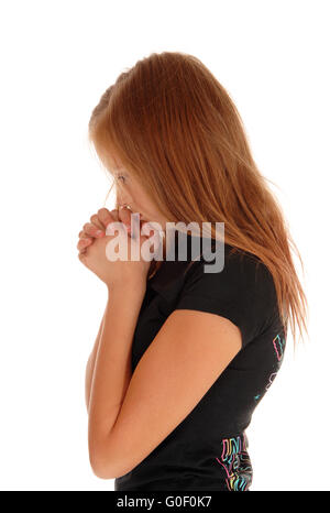 Girl standing in profile and praying. Stock Photo