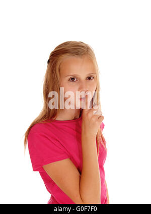 Pretty blond girl with finger over mouth. Stock Photo