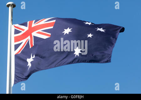 Commonwealth star and Southern cross white stars on Australian Flag flying on a mast, blue sky, Australia Stock Photo