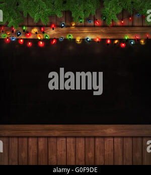 Christmas holiday lights on wooden blackboard Stock Photo