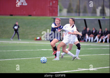 Opposing players in a battle for control of the ball in front of the goal during a high school soccer match. USA. Stock Photo