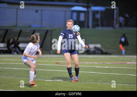 Player contending with an elevated ball as an opposing defender looks on at the action hoping to seize control of the ball. USA. Stock Photo