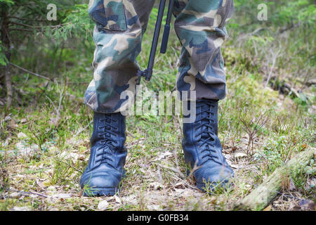 Soldier's legs in army boots in a forest Stock Photo