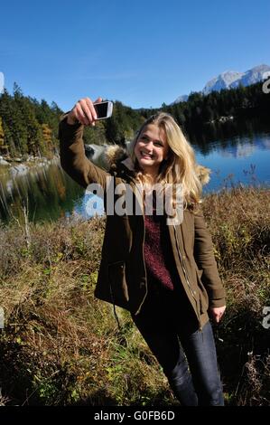 blonde woman taking a selfie on the beach at sunset Stock Photo - Alamy