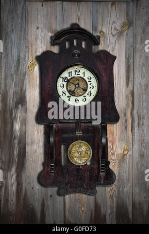 old pendulum clock on the background of wooden wall Stock Photo