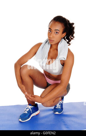 Beautiful woman crouching in sportswear. Stock Photo