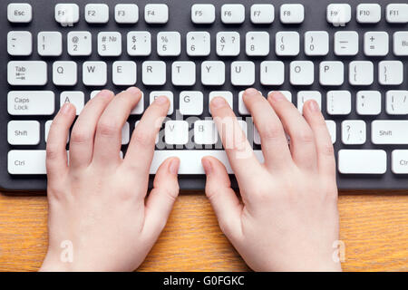 Top view of hands typing on computer keyboard Stock Photo