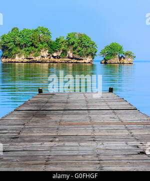 wooden batten bridge juts out into the expanse of the sea Stock Photo