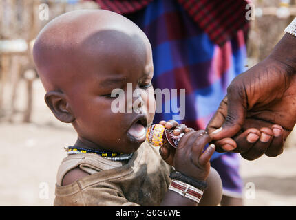 Maasai child trying a lollipop in Tanzania, Africa Stock Photo