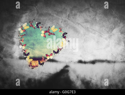 Heart shape made of colorful butterflies on black and white field vintage background. Love Stock Photo