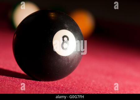 Billards pool or snooker game. The black eight ball. Red cloth table Stock Photo