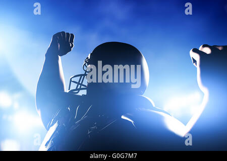 American football player celebrating score and victory. Night stadium lights Stock Photo