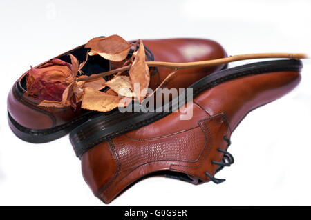 Mans shoes with dried rose on top Stock Photo