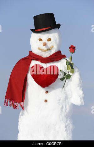 snow man with red rose and red heart as gentleman Stock Photo