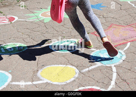 girl runs on the childish drawings on the asphalt of street Stock Photo