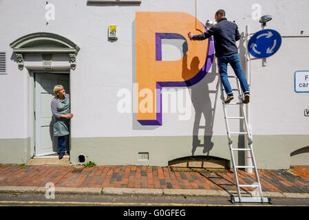 Celebrating 100 years of London Underground's world famous typeface, artist Gary Stranger paints letters on walls in Ditchling. Stock Photo