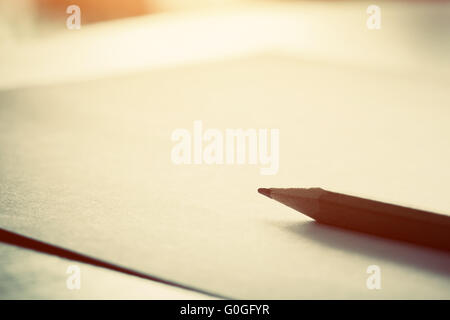 Pencil lying on blank piece of paper in morning light. Creative work Stock Photo