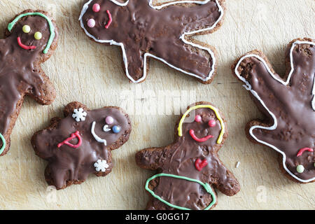 Handmade decorated gingerbread people lying on wooden table. Christmas Stock Photo