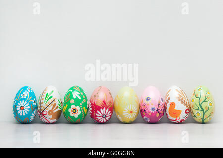 Handmade Easter eggs collection on white wall. Floral Stock Photo