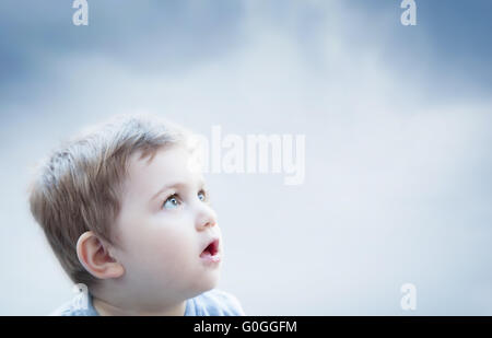 Boy looking at the sky with surprised expression. Child imagination Stock Photo