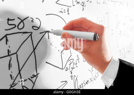 Man writing complex math formulas on whiteboard. Mathematics and science Stock Photo