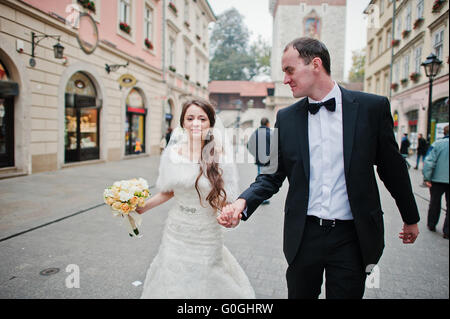 Young elegant and hearty wedding couple in love on streets of Krakow, Poland Stock Photo