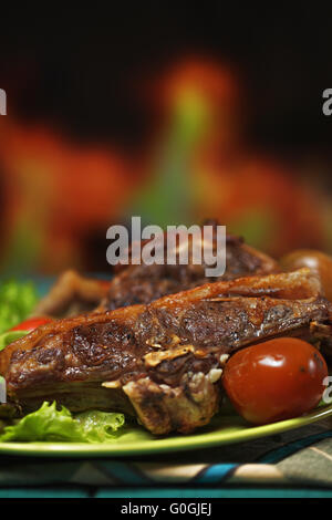 Grilled lamb against fireplace Stock Photo