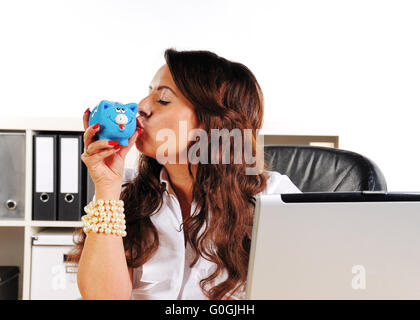 woman to kiss a piggy bank in the office Stock Photo