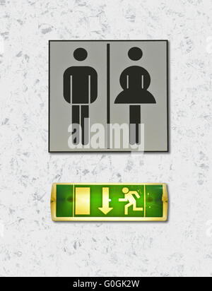 toilette sign with female and male symbol and ligthing escape route indicator Stock Photo