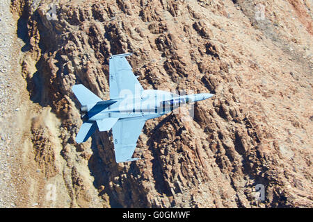 United States Navy F/A-18F Super Hornet Banking Steeply Through Rainbow Canyon. Stock Photo