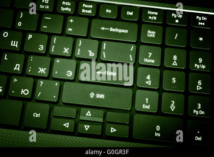Laptop keyboard. The focus on the Enter key. Toning is green. Stock Photo