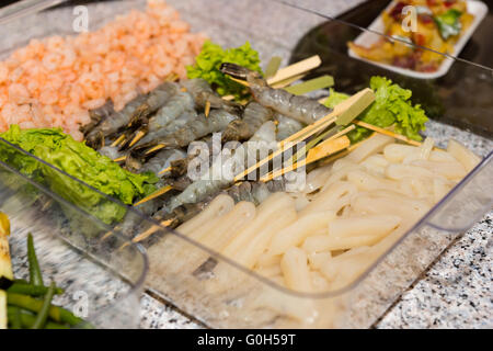 Close Up Still Life of Raw Prepared Fish, Shrimp and Seafood in Plastic Tray Ready for Grilling at Self Serve Restaurant Banquet Buffet. Stock Photo