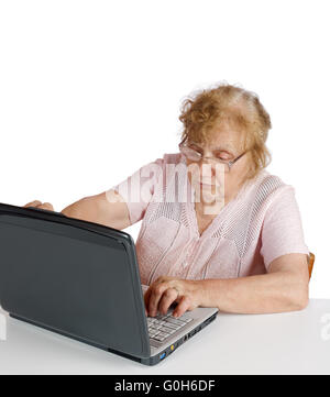 granny in glasses looks at the screen notebook on a white background Stock Photo