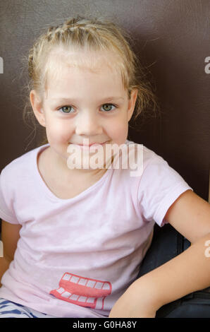 Happy girl sitting on a chair in an electric train, close-up Stock Photo