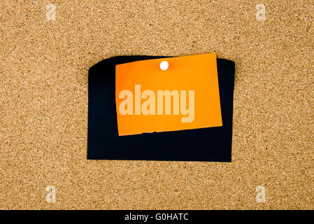Blank black and orange paper notes pinned on cork board with white thumbtack, copy space available Stock Photo