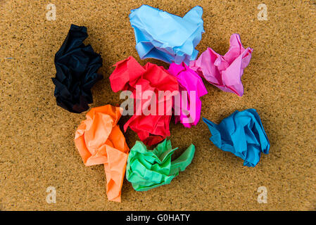 Colorful crumpled papers over cork background Stock Photo