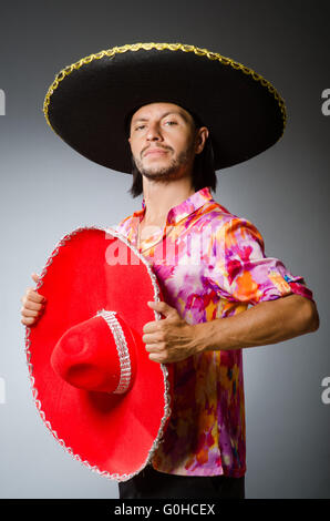 Young hispanic man wearing mexican hat holding chili thinking attitude