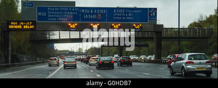 Traffic jam on motorway with gantry matrix sign displaying Severe Delay Stock Photo