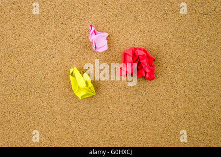 Colorful crumpled papers over cork background Stock Photo