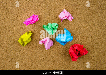 Colorful crumpled papers over cork background Stock Photo