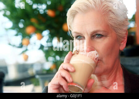 woman in the early 50th with a latte macchiato Stock Photo