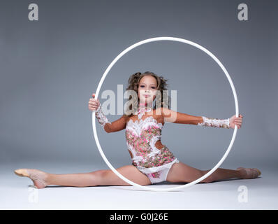 Adorable young artistic gymnast sitting on split Stock Photo