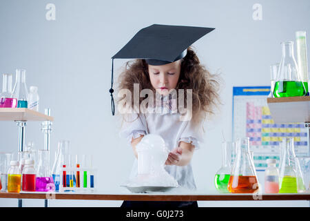 Curious girl watching result of experiment in lab Stock Photo