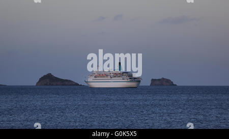 Torbay, Devon, UK, 02 May 2016. The German cruise liner MS Albatros, on a 9 day cruise, visits Torquay in Devon on the May Day Bank Holiday. The large liner anchored in Torbay and passengers were ferried to Torquay. The ship departed for Guernsey as the sun set; seen here turning away from the bay with Thatcher Rock and Ore Stone in the background. Credit:  Clive Jones/Alamy Live News Stock Photo