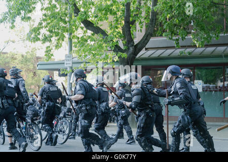 Seattle, WA, USA. 1st May, 2016. Police officers suddenly charge toward aggressive group of protesters and redirect a marching route. Stock Photo