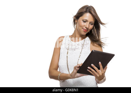 Woman chatting on a mobile while reading a tablet Stock Photo