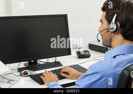 Man wearing headset giving online chat and support Stock Photo